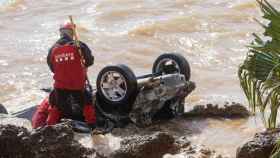 Los bomberos comprueban un coche arrastrado por las inundaciones en Alcanar / EFE