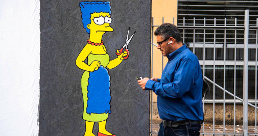 Un mural creado por el artista callejero AleXsandro Palombo muestra a Marge Simpson, personaje de la serie 'The Simpsons,' cortando su pelo en solidaridad con Mahsa Amini y para protestar contra el régimen iraní, hoy en Milán - EFE/ANDREA FASANI