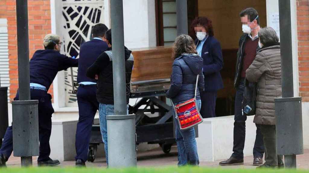 Operarios de la funeraria de Madrid conducen un féretro