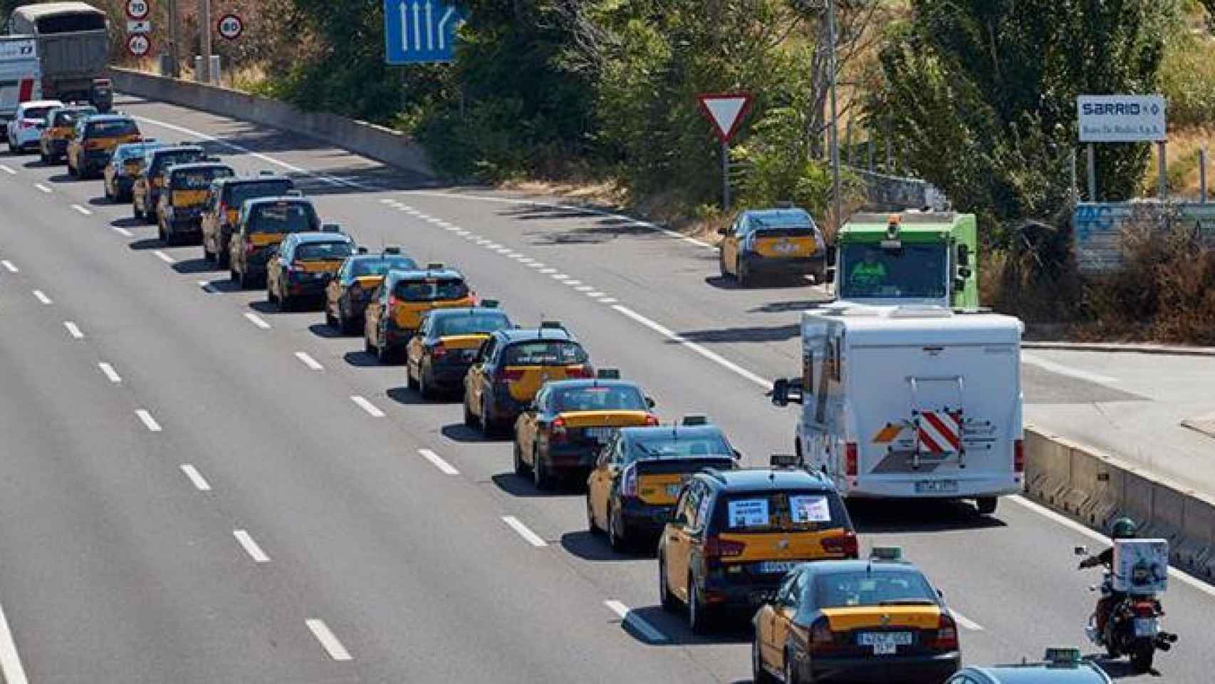 Cientos de taxistas participan en la marcha lenta desde al aeropuerto de El Prat hasta el puerto de Barcelona por la Ronda Litoral durante la huelga contra Uber y Cabify