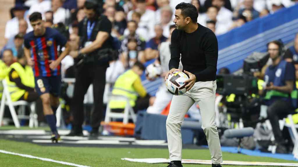 Xavi Hernández, cogiendo un balón para intentar que el Barça saque rápido de banda / EFE