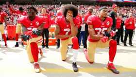 Colin Kaepernick (centro) y sus compañeros protestando contra el racismo / EFE