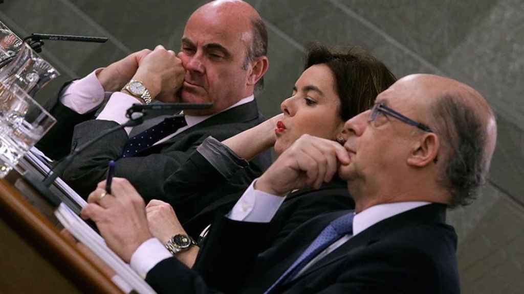 Luis de Guindos (Economía), Soraya Sáenz de Santamaría y Cristóbal Montoro (Hacienda) en la rueda de prensa tras el Consejo de Ministros.