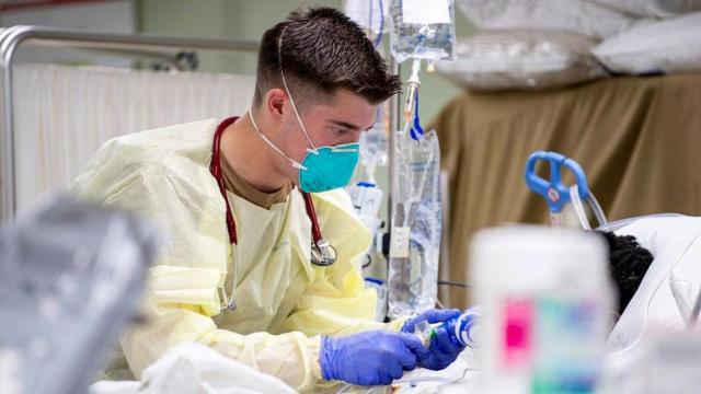 El trabajador de una residencia atiende a un paciente con coronavirus / EFE