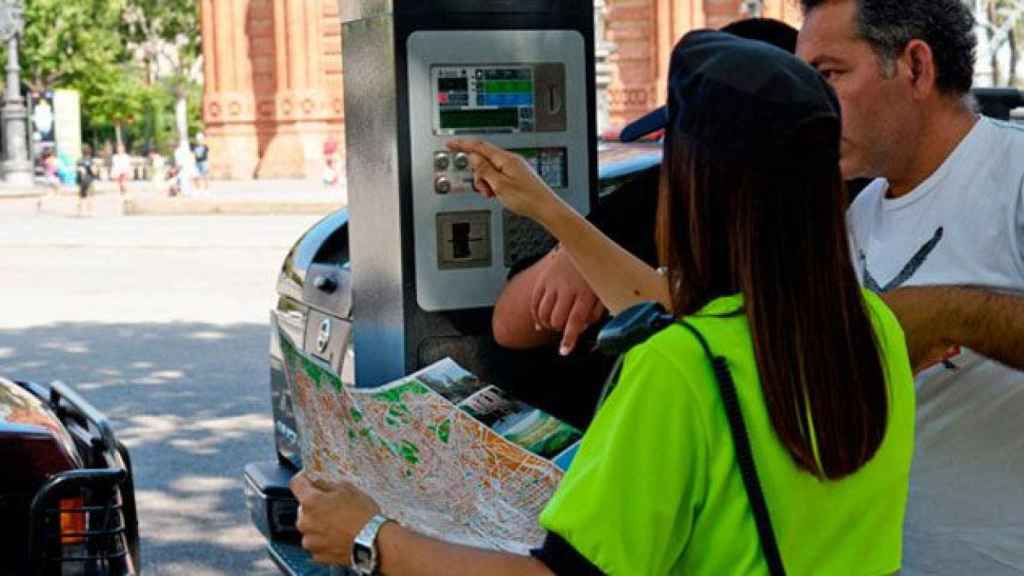 Una agente del área verde de Barcelona, ayudando a un conductor / CG