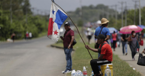 Un hombre sostiene una bandera panameña sobre una vía que permanece cerrada por manifestantes, hoy, en un puente que pasa sobre el río Pacora, en el corregimiento del mismo nombre al este del área metropolitana de Ciudad de Panamá (Panamá) - EFE/ Bienvenido Velasco
