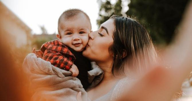 Una madre dando un beso a su hijo / Omar López en UNSPLASH