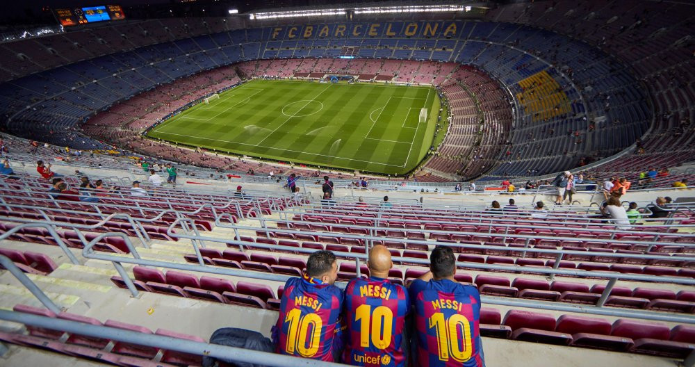 Una foto de tres aficionados del Barça en el Camp Nou / EFE