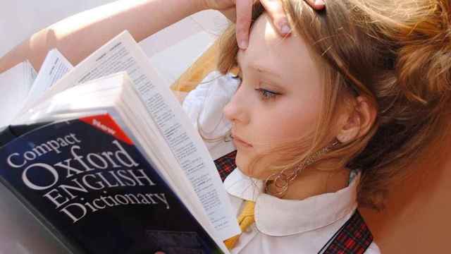 Una chica con bilingüismo consulta un diccionario de inglés / PIXABAY