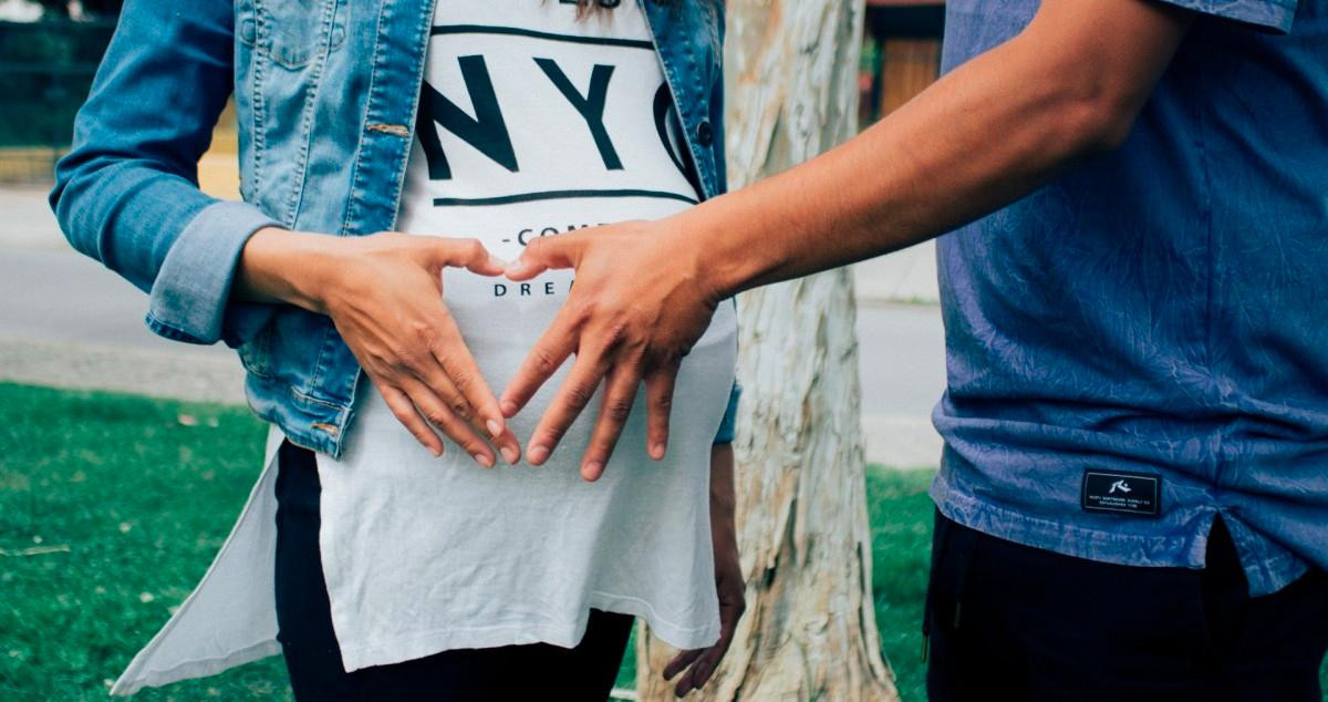 Una pareja forma un corazón con sus manos / PXHERE