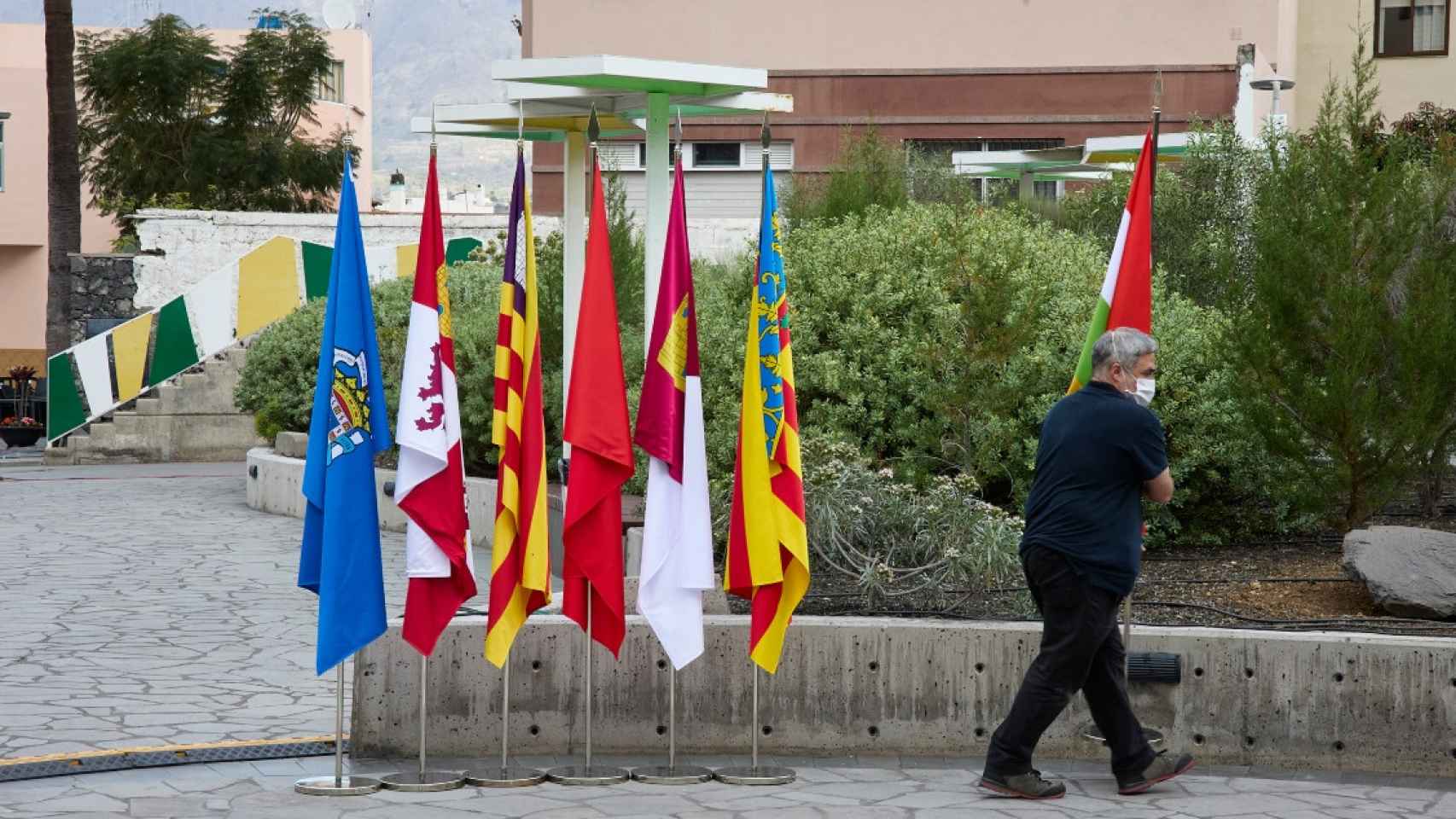 Un operario retira banderas de varias comunidades autónomas / EP