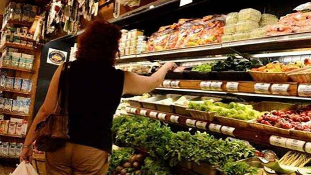 Imagen de archivo de una mujer cogiendo productos en un supermercado, compras que se reflejan en el consumo interno del país / EFE