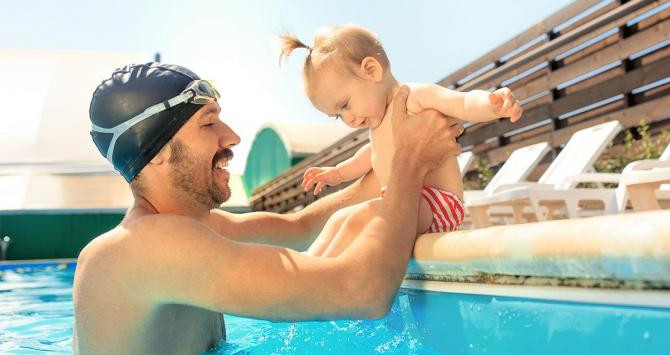 Un padre con su hija en la piscina / FREEPIK