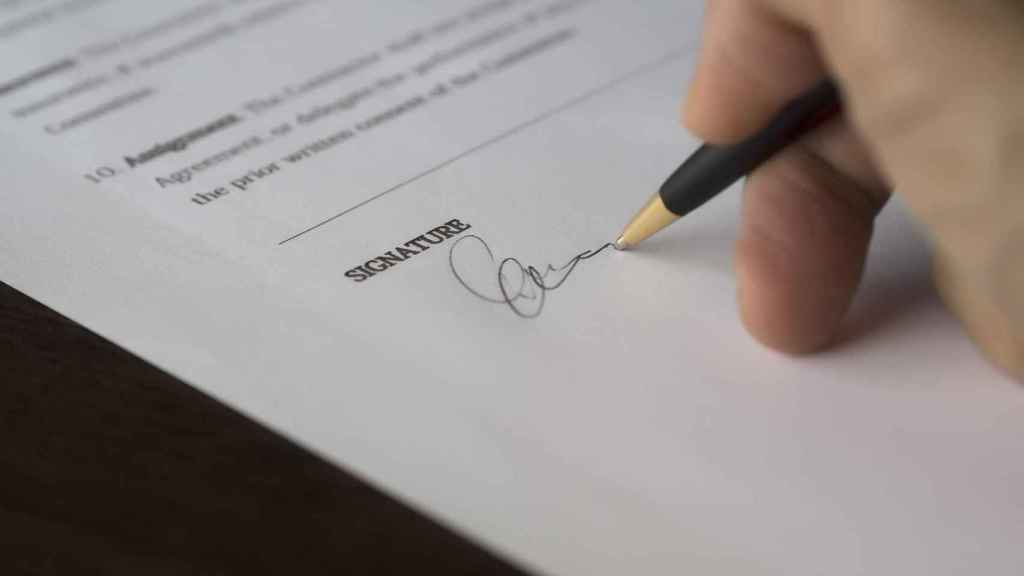 Un hombre firma un contrato / CG