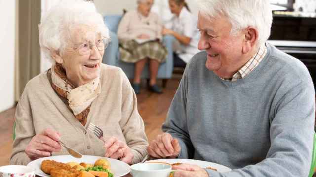 Dos ancianos comen alimentación en una residencia