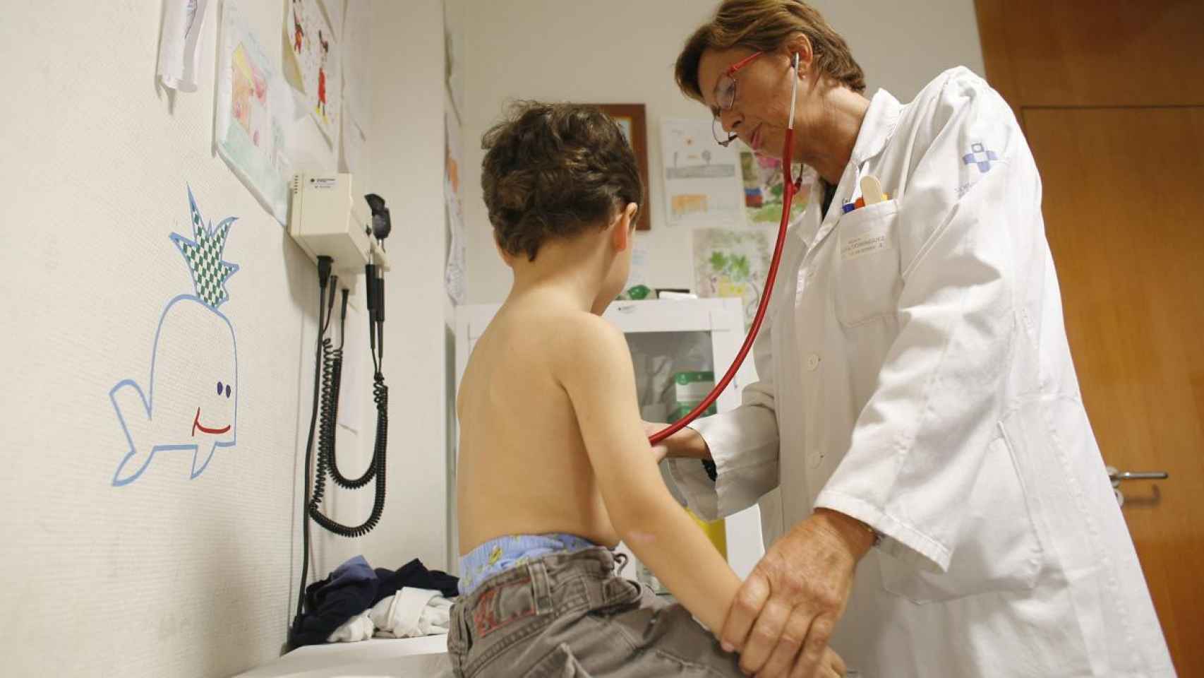 Una pediatra pasa consulta a un niño