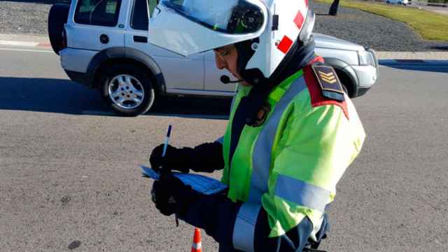 Un mosso d'Esquadra poniendo una multa a un conductor / MOSSOS