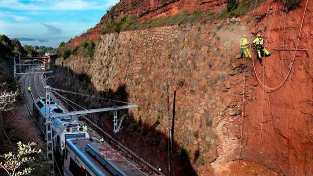 Técnicos de Adif trabajan en Vacarisses (Barcelona) para afianzar el talud y retirar de la vía el tren que ayer descarriló por un desprendimiento de tierras / EFE