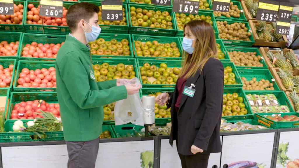 Dos empleados de Mercadona con una de las nuevas bolsas compostables de la compañía / MERCADONA