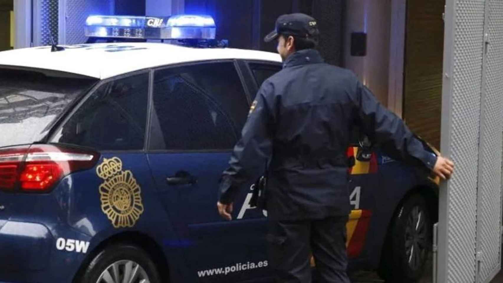 Un coche y un agente de la policía nacional / POLICIA NACIONAL