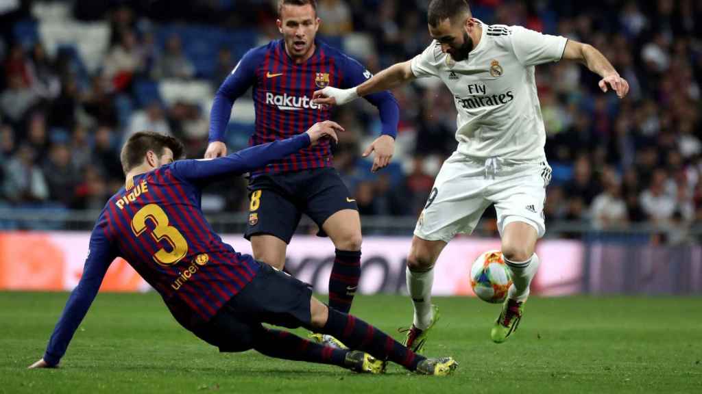 Gerard Piqué con Karim Benzema en el clásico liguero / EFE