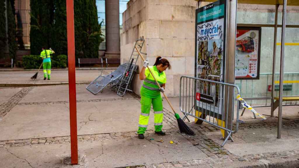 Dos empleados municipales limpian una calle de Barcelona tras las fiestas de La Mercè / KIKE RINCÓN - EUROPA PRESS