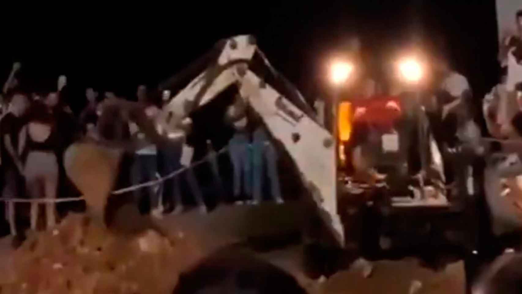 Un participante del macrobotellón de la UAB se monta en una excavadora