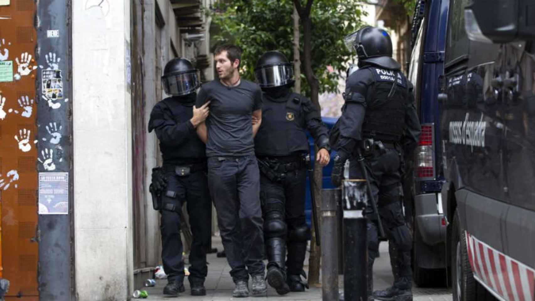 Un joven de los que habían conseguido entrar en el 'Banc Expropiat' cuando ha sido desalojado por los Mossos d'Esquadra.