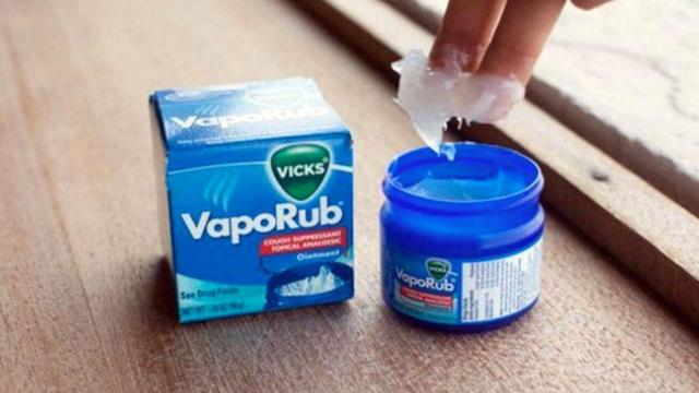 Una persona unta sus dedos en Vicks VapoRub