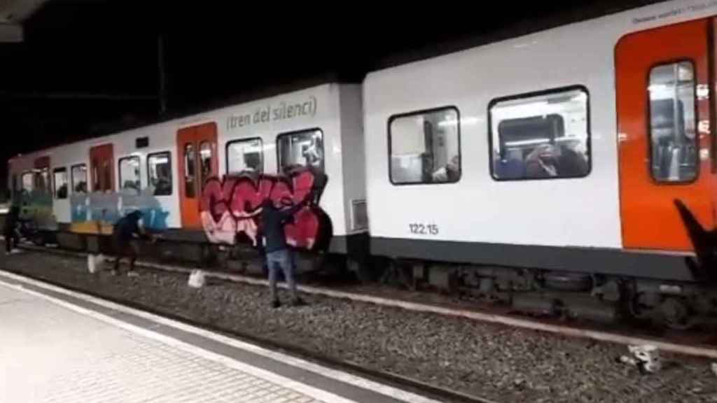 Un grupo de grafiteros, pintando un convoy de Ferrocarrils de la Generalitat en la estación Hospital General / @AdnCataluna (TWITTER)