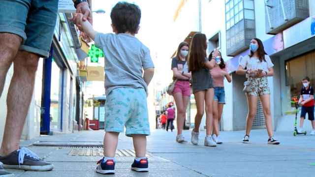 Un niño de la mano de su padre mira a un grupo de chicas en la calle / EUROPA PRESS