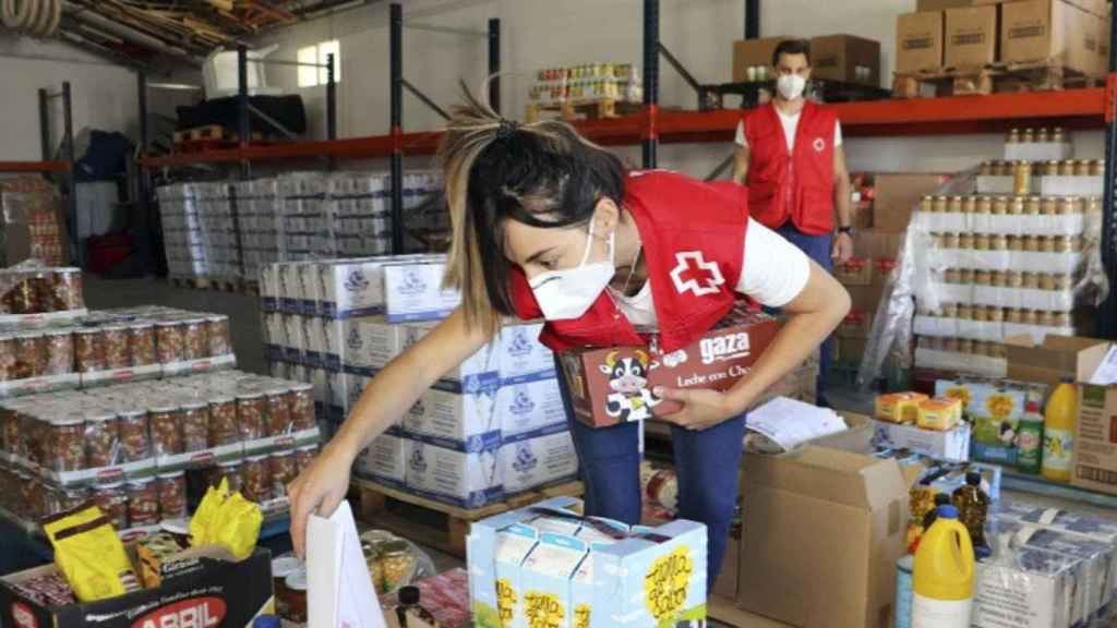 Una voluntaria de Cruz Roja prepara los packs de comida / CREU ROJA