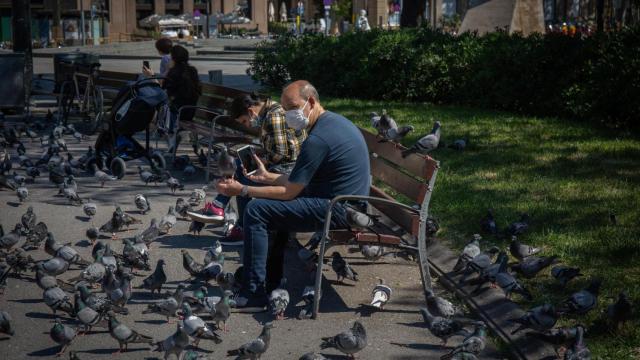 Varias personas descansan en un parque de Barcelona protegidos del coronavirus con una mascarilla / EP