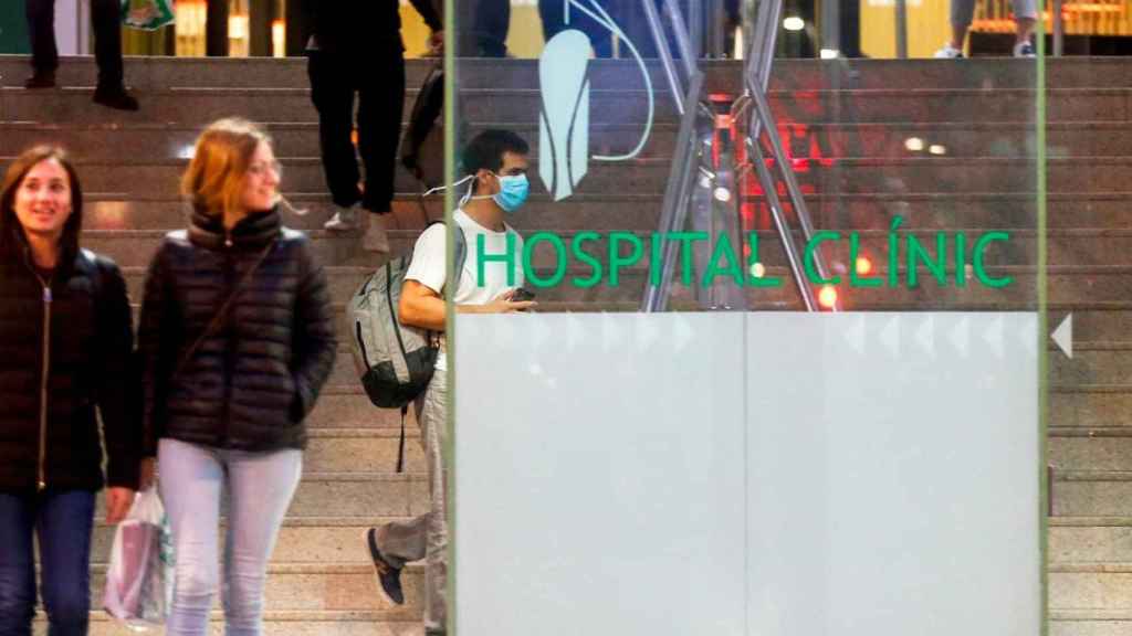 Un chico con una mascarilla respiratoria en el acceso al Hospital Clínic Barcelona / EFE