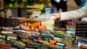 Una librera vende un libro a una mujer durnate Sant Jordi en Barcelona / EFE