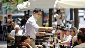 Un camarero atiende a unos turistas en una terraza en Cataluña / EFE