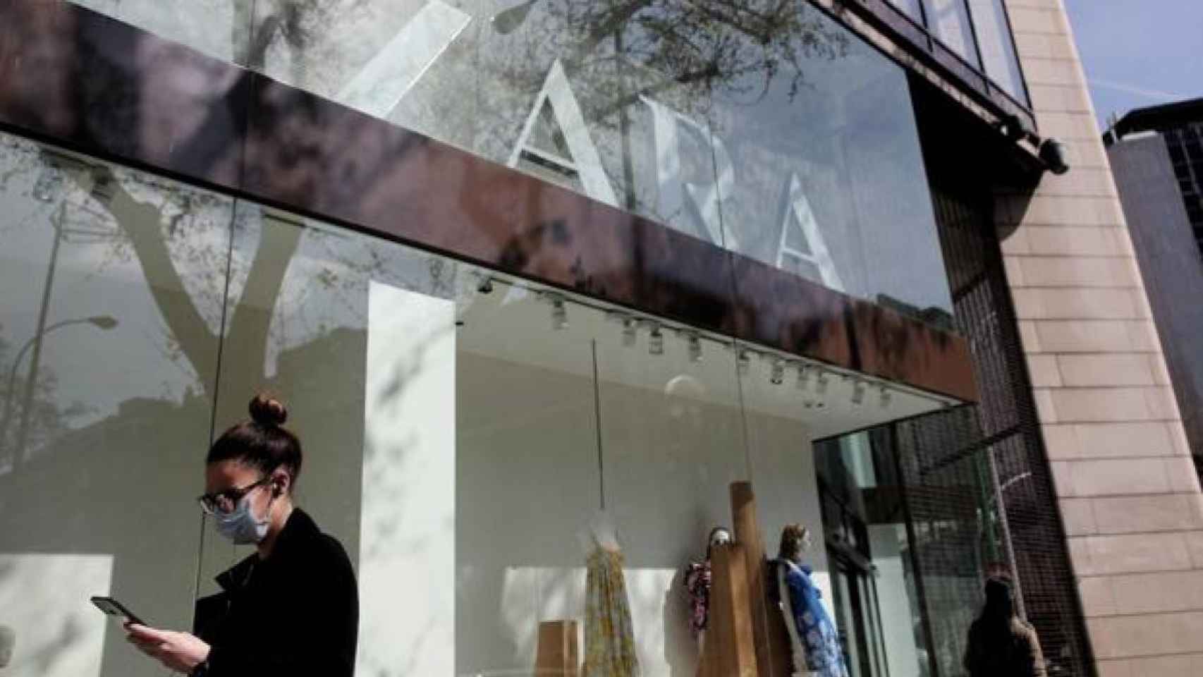 Una mujer con mascarilla pasa por delante de un escaparate de Zara / EP