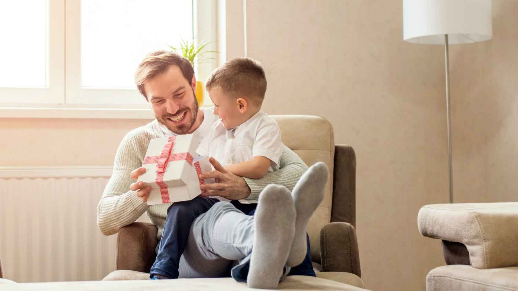 Padre con un niño abriendo un regalo / ARCHIVO