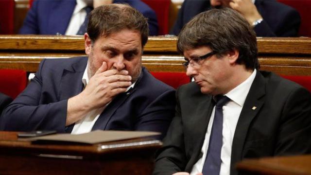 El presidente catalán, Carles Puigdemont (d) y el vicepresidente económico, Oriol Junqueras, hablan en el Parlament / EFE
