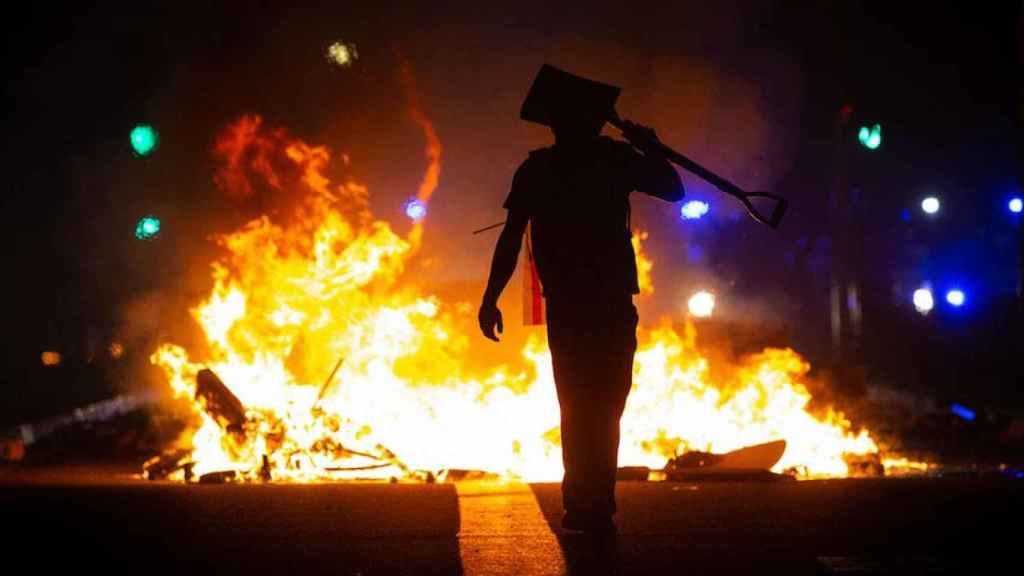 Un manifestante ante una barricada en llamas durante los disturbios en Barcelona, Cataluña / EUROPA PRESS