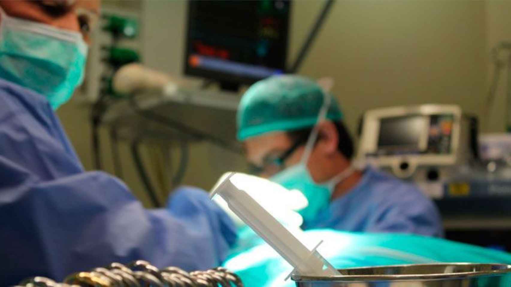 Dos cirujanos operando a un paciente en un hospital / EP