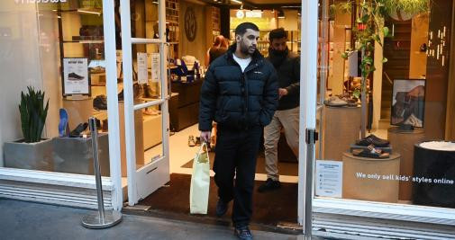 Un cliente sale del interior de una tienda, el primer día del fin de restricciones / Efe