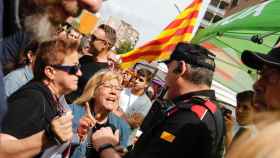 Dos mujeres protestan ante un Mosso d'Esquadra en el escrache a la parada de Sant Jordi de Vox en Sabadell / GALA ESPÍN