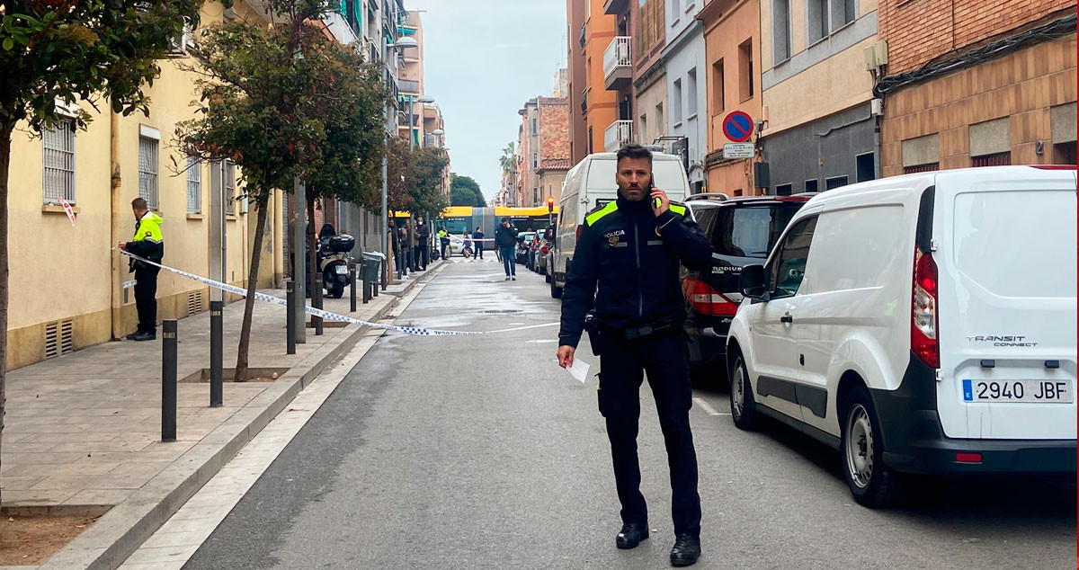 Un agente de la Guardia Urbana corta la calle en el lugar del incendio en Santa Coloma de Gramenet / NC