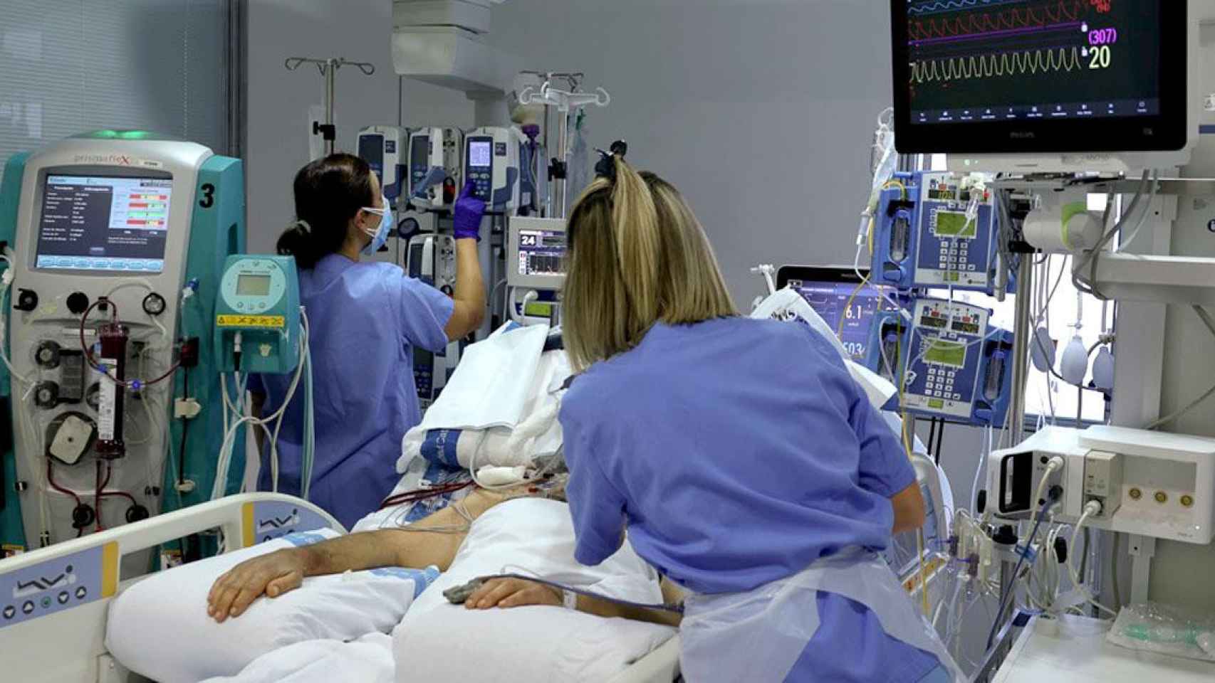 Dos sanitarias atienden a un paciente de coronavirus en la UCI del Hospital Universitari de Bellvitge / EP