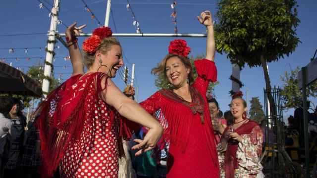 Mujeres bailando ataviadas con el traje de gitana en la Feria de Abril / EFE