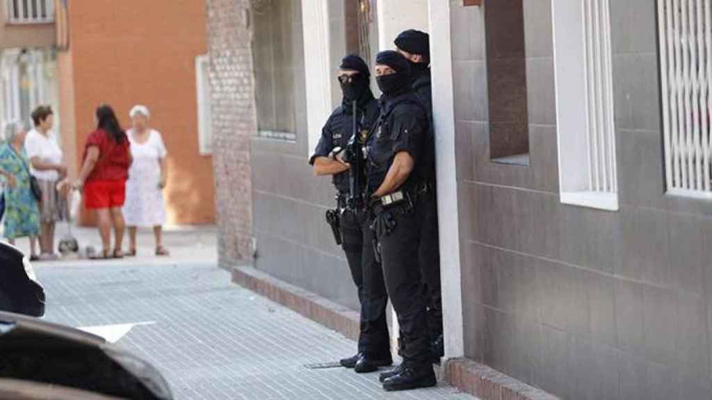 Los Mossos d'Esquadra custodian el edificio donde vivía el que hombre ha sido abatido esta mañana al intentar acceder a la con un cuchillo en la mano y al grito de Alá es grande en la comisaría de los Mossos en Cornellà / EFE