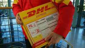 Hombre con un paquete, pieza de la red logística del e-commerce / DHL