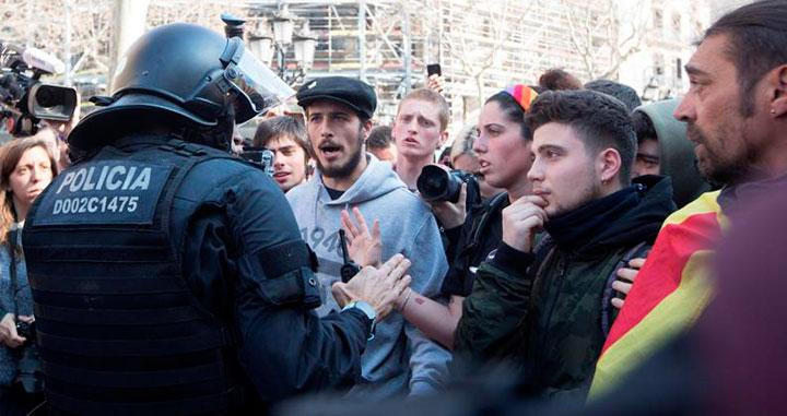 Un agente de los Mossos d'Esquadra habla con los manifestantes del 21F / EFE