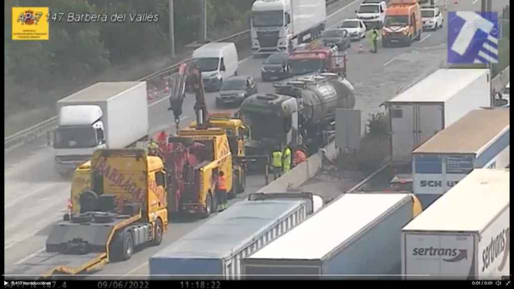 Imagen de una cámara del Servei Català de Trànsit (SCT) de este jueves donde se ven los servicios de emergencias retirando el camión cisterna accidentado en la AP-7 / TRÀNSIT